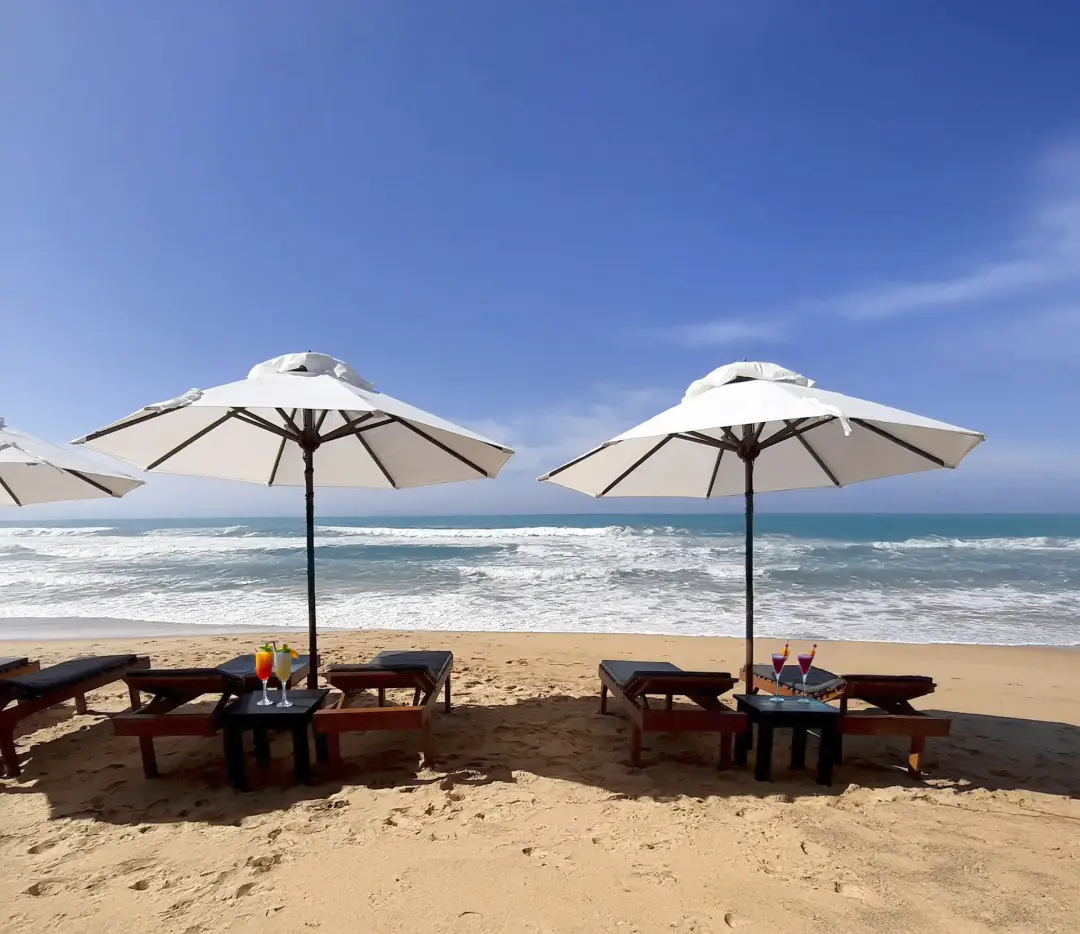 Plage privée de sable fin de la Villa Kusum à Hikkaduwa, avec transats confortables face à l'océan Indien, cadre exclusif pour les participants du séjour yoga.