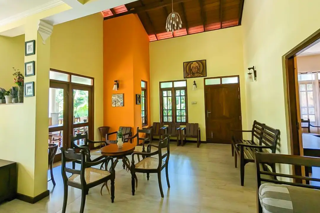 Hall d'accueil avec petites tables et fauteuils - entrée de la villa Kenzen pour retraite yoga Hikkaduwa