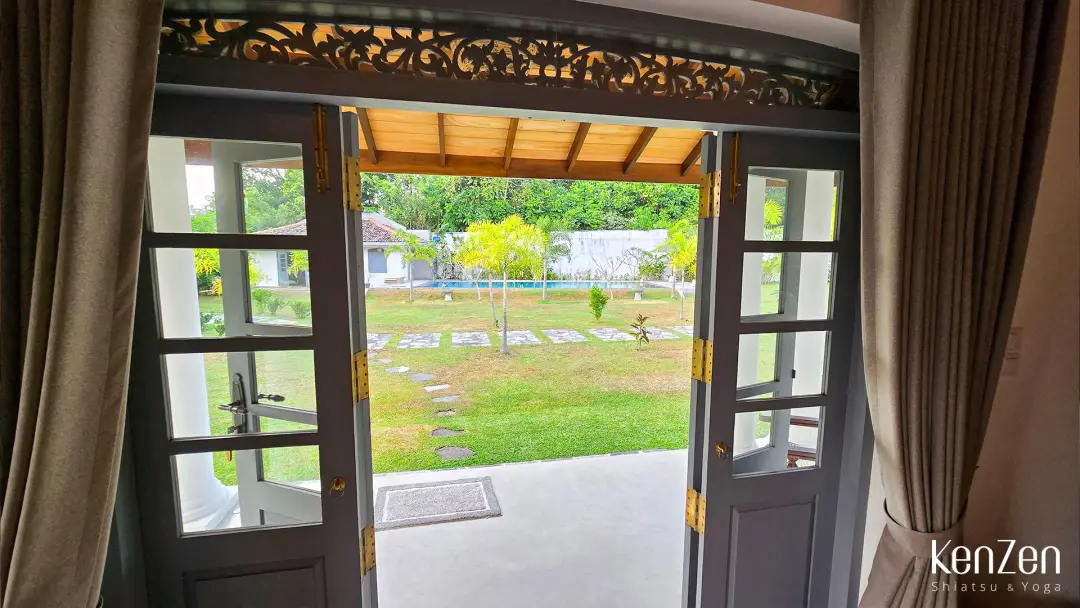 Terrasse privative de la suite Jasmin avec vue sur le jardin tropical et la piscine de la villa.