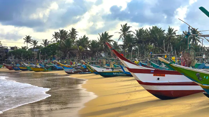 Ambiance locale sur la plage d'Hikkaduwa : pêcheurs, promeneurs et sourires, immersion authentique au Sri Lanka.