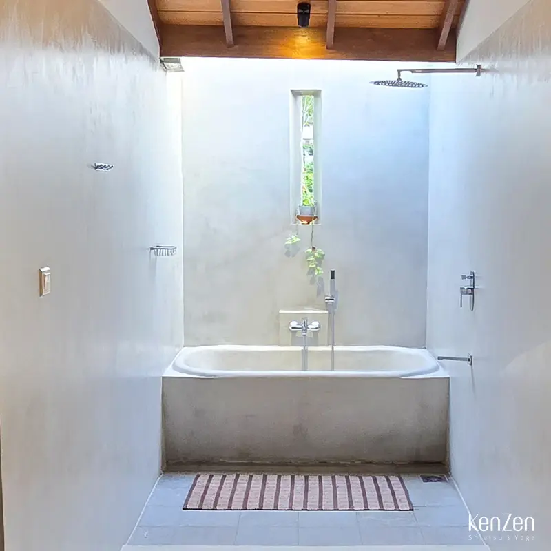 Salle de bain privative de la suite Paradis avec baignoire à ciel ouvert sur la nature, pour un bain étoilé.