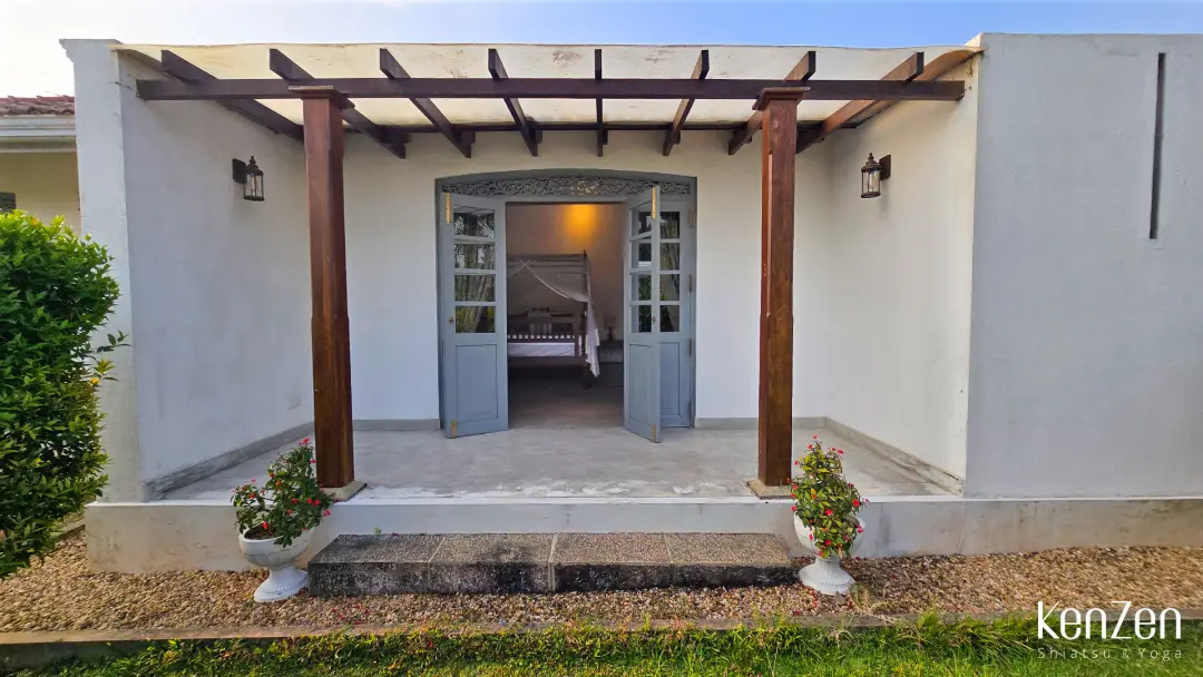 Coin détente sur la terrasse privative de la chambre Hibiscus, au cœur d'un jardin luxuriant. | KenZen Shiatsu et Yoga