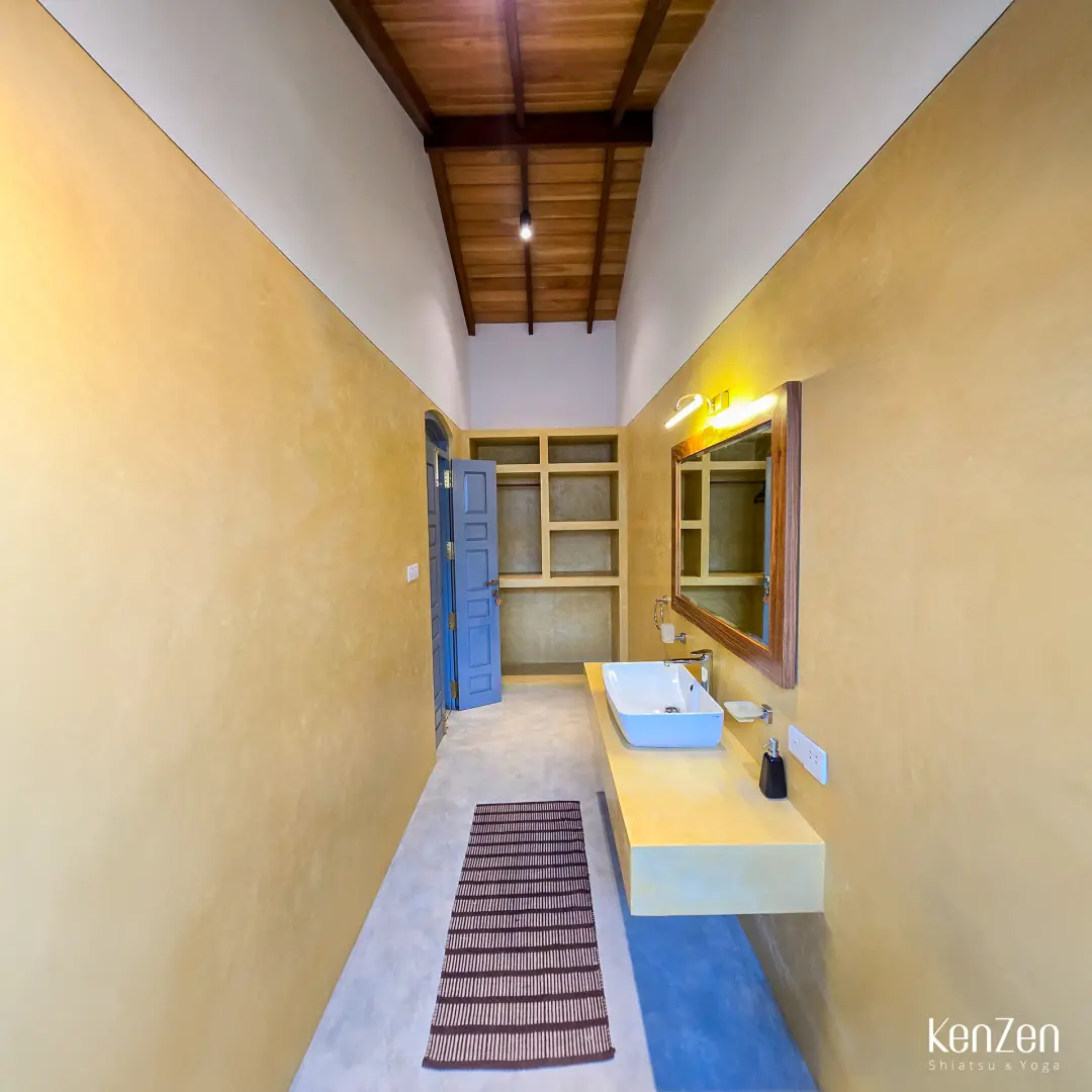 Salle de bain privative spacieuse et lumineuse de la suite Hibiscus, avec douche et vasque.